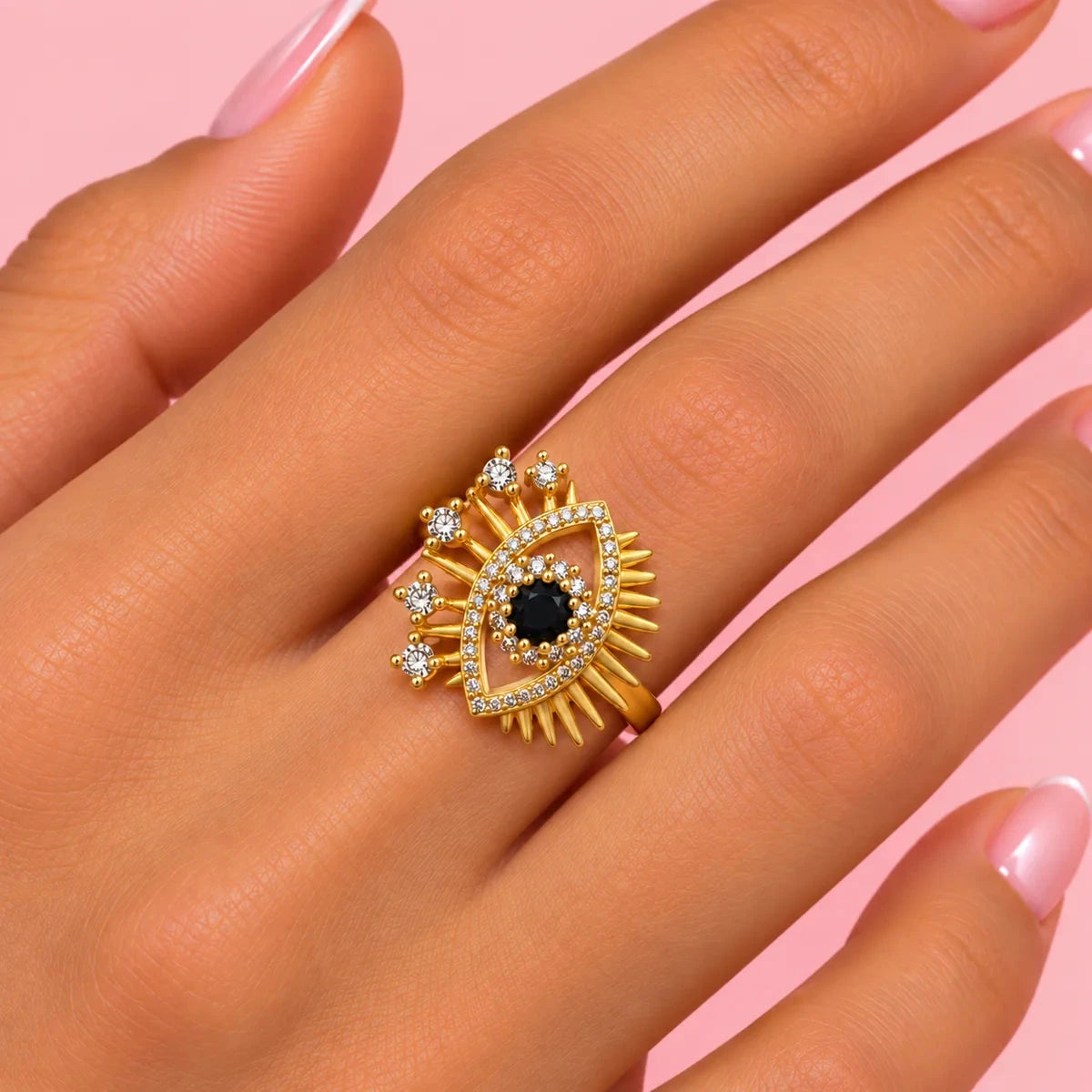 Bague Kallima œil grec dorée portée à la main, pavée de zircons blancs avec pierre noire centrale
