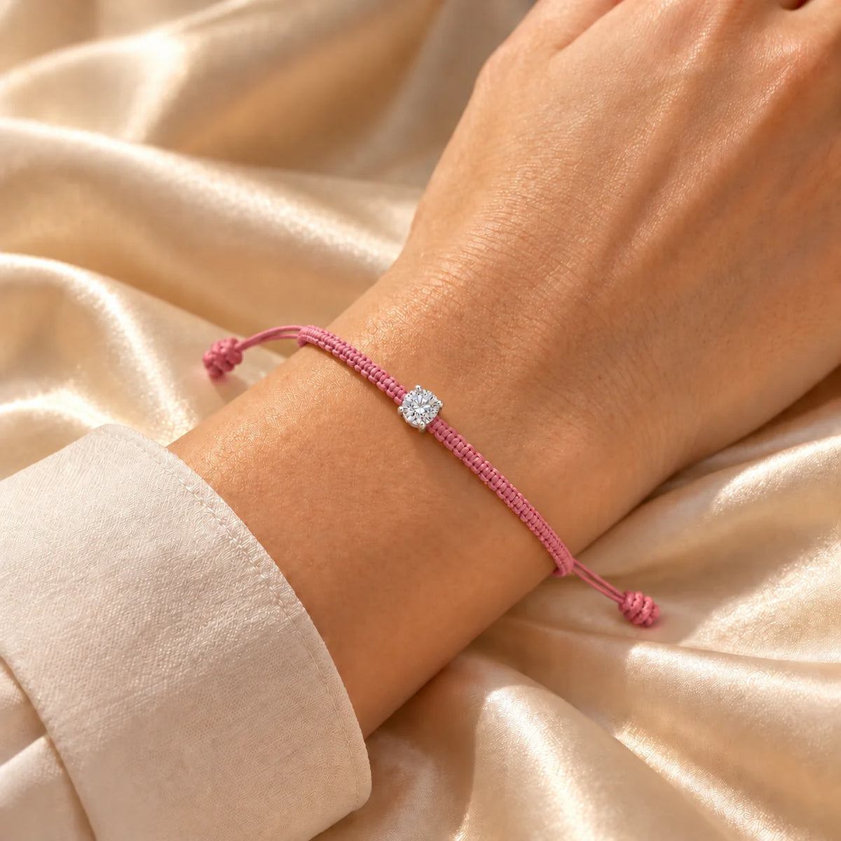 Bracelet cordon tressé rose ajustable serti d’un diamant de laboratoire, porté au poignet
