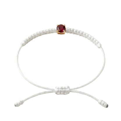 Bracelet cordon blanc, pierre de rubis rouge de laboratoire sertie sur or
750/1000, fermoir coulissant réglable
