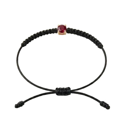 Bracelet cordon noir, pierre de rubis rouge de laboratoire sertie sur or 750/1000,
fermoir coulissant réglable