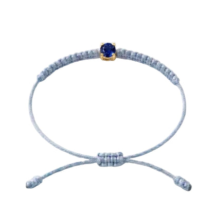 Bracelet cordon bleu ciel, pierre de saphir bleu de laboratoire sertie sur or
750/1000, fermoir coulissant réglable

