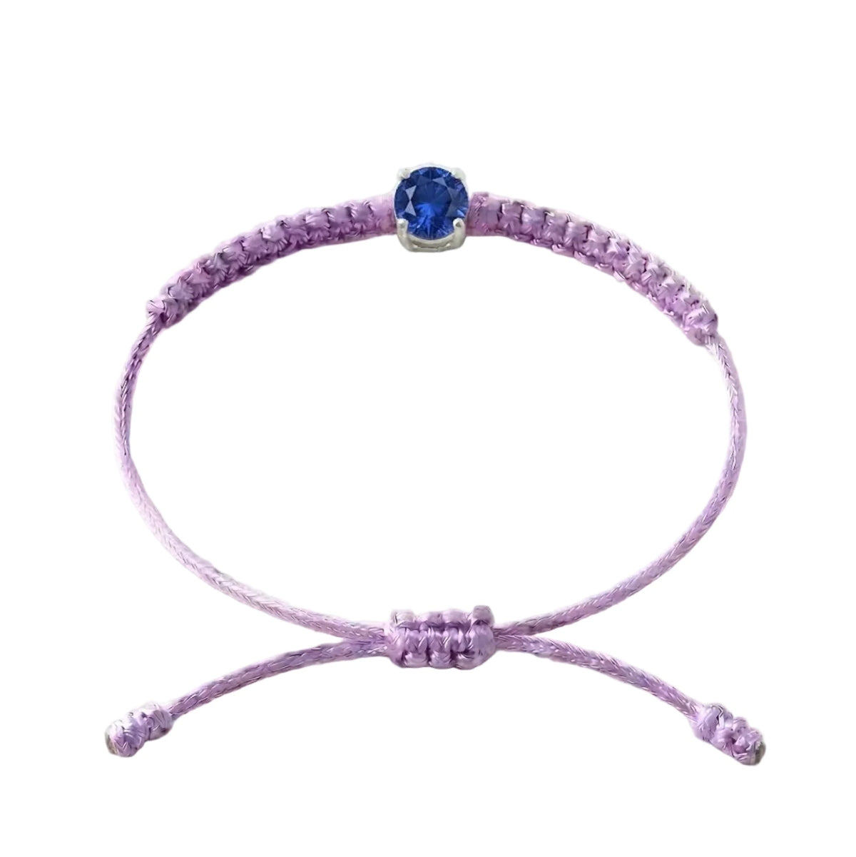 Bracelet cordon lilas, pierre de saphir bleu de laboratoire sertie sur or 750/1000,
fermoir coulissant réglable
