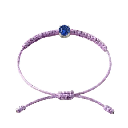 Bracelet cordon lilas, pierre de saphir bleu de laboratoire sertie sur or 750/1000,
fermoir coulissant réglable
