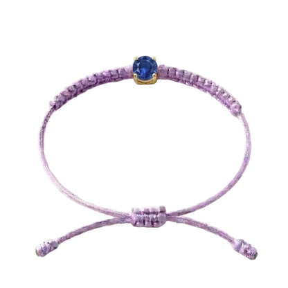 Bracelet cordon lilas, pierre de saphir bleu de laboratoire sertie sur or 750/1000,
fermoir coulissant réglable
