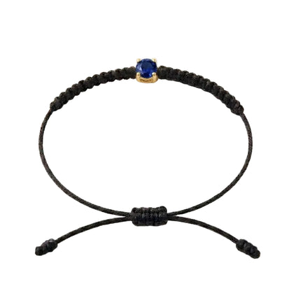 Bracelet cordon noir, pierre de saphir bleu de laboratoire sertie sur or 750/1000,
fermoir coulissant réglable

