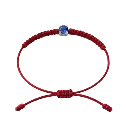 Bracelet cordon rouge, pierre de saphir bleu de laboratoire sertie sur or
750/1000, fermoir coulissant réglable