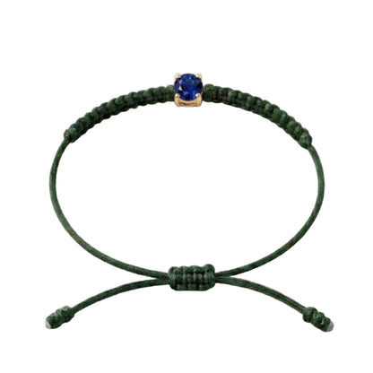 Bracelet cordon vert sapin, pierre de saphir bleu de laboratoire sertie sur or
750/1000, fermoir coulissant réglable

