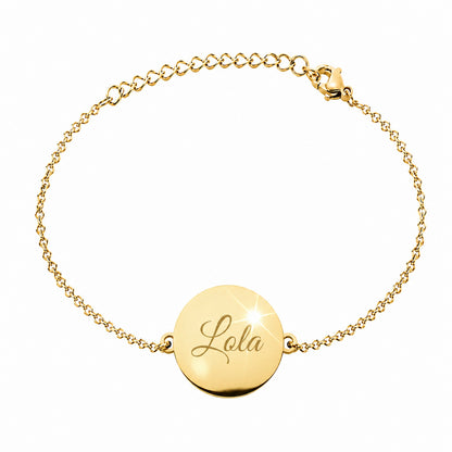 Bracelet personnalisé en acier doré avec médaille ronde gravée "Lola", chaîne fine ajustable et finition polie sur fond blanc.