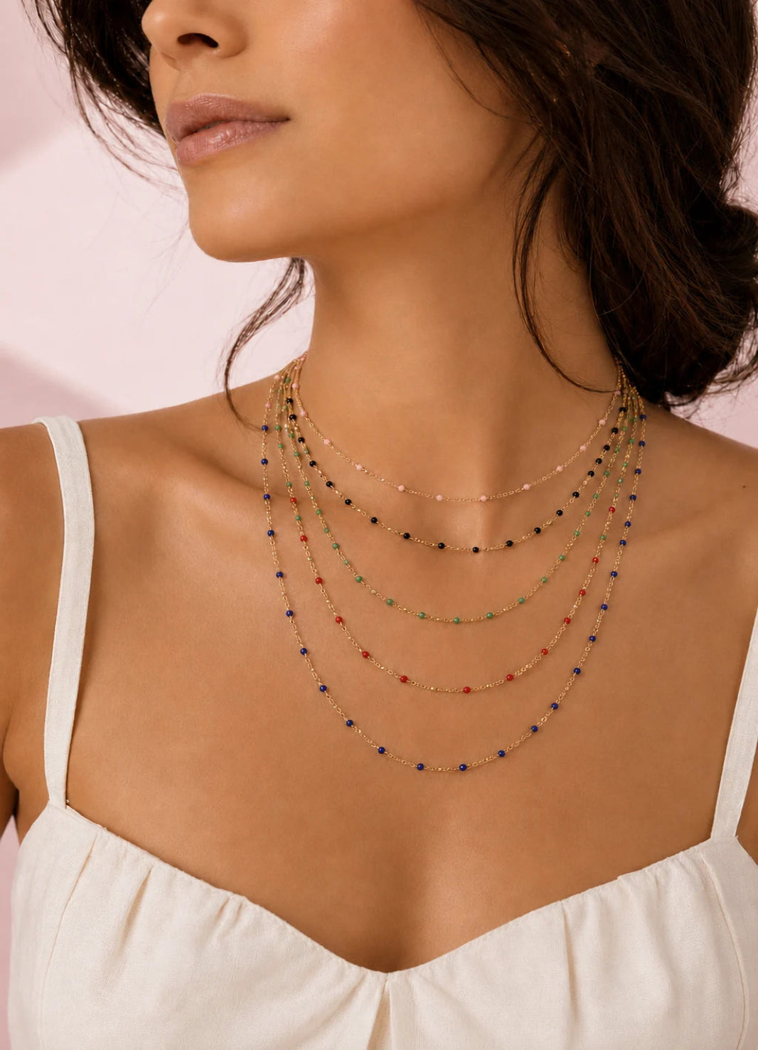 Collier femme en acier inoxydable doré à perles de résine colorées porté autour du cou