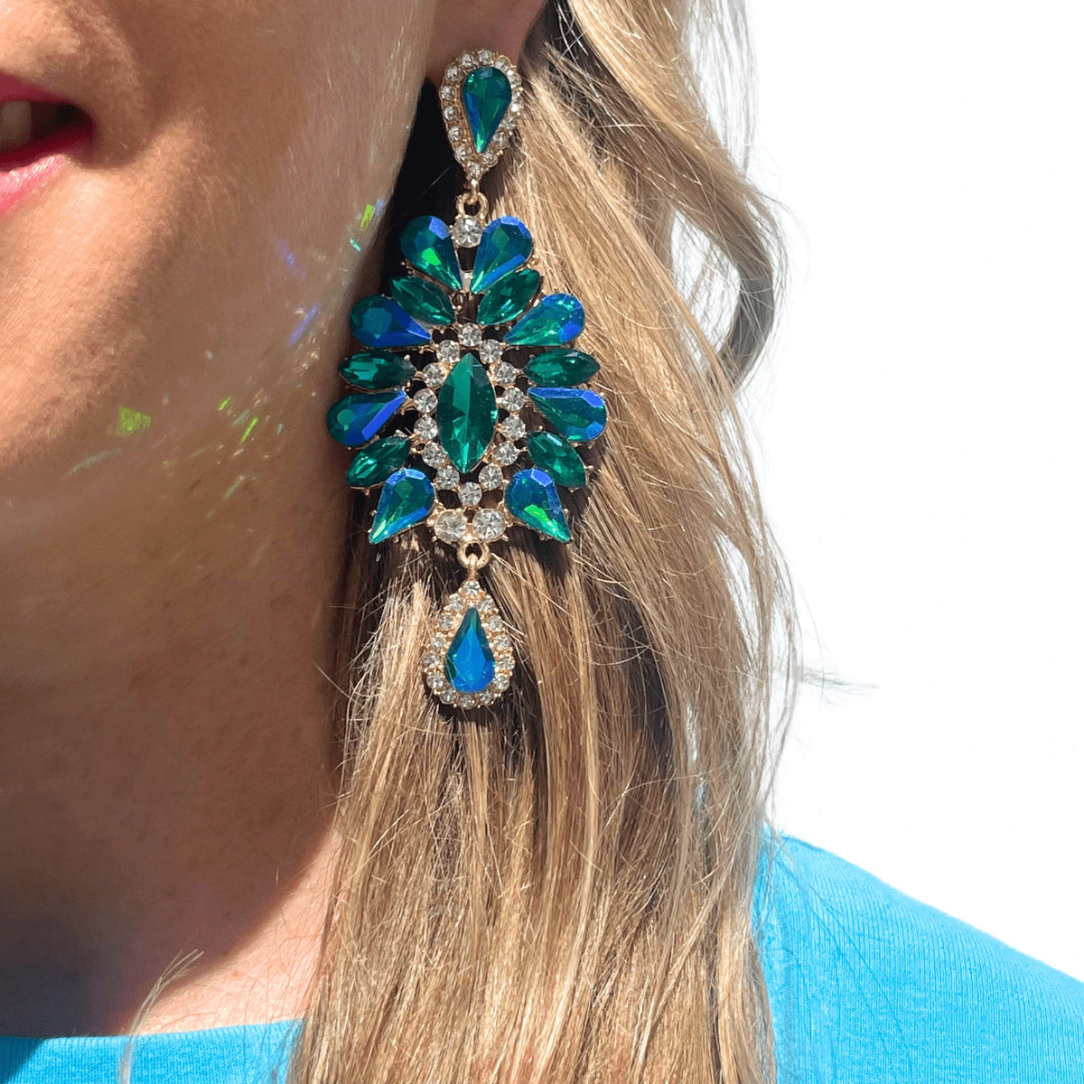 Femme portant des boucles d'oreilles pendantes Éclosions bleues, style élégant et délicat