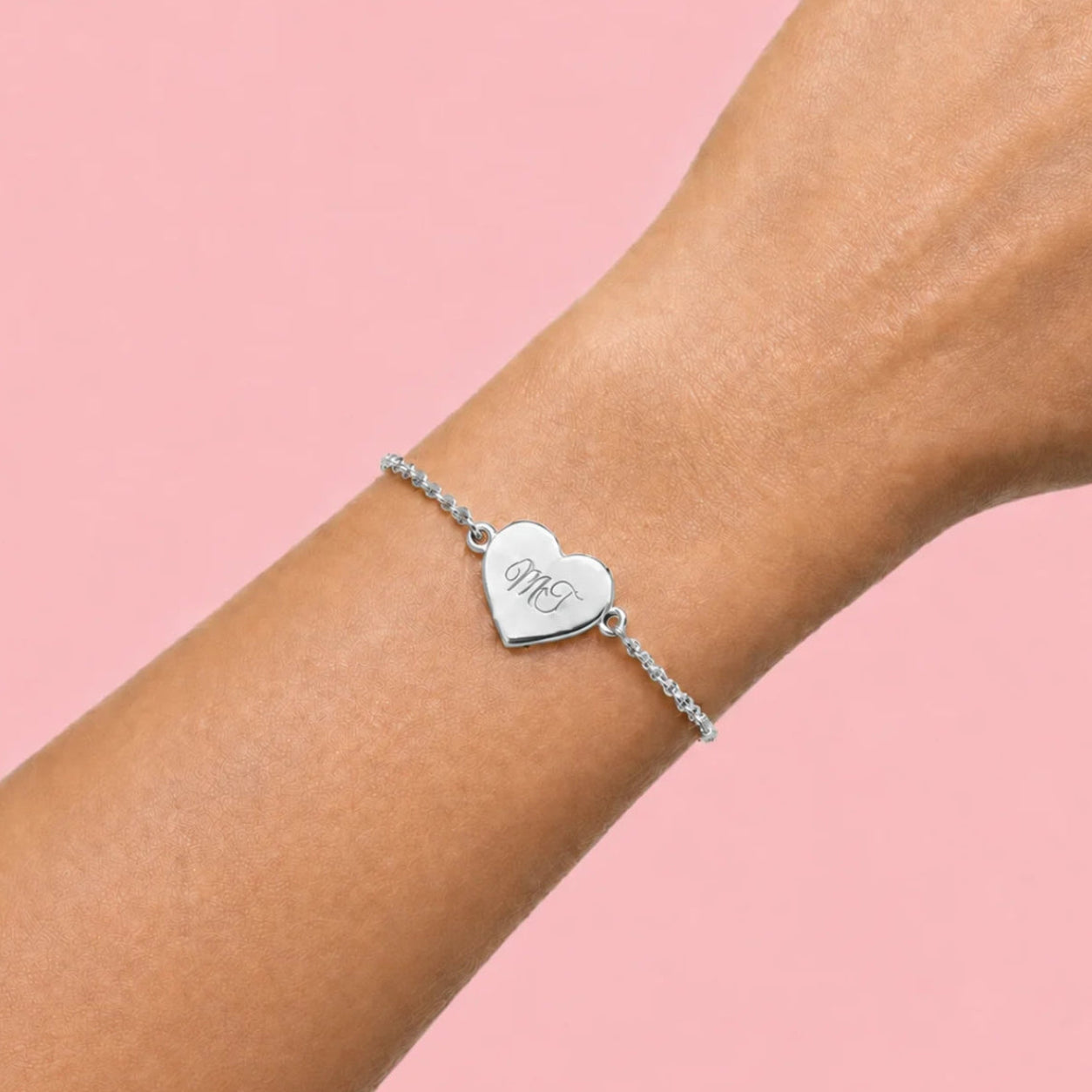 Bracelet cœur gravure ajustable porté au poignet, finition argent, mousqueton sécurisé