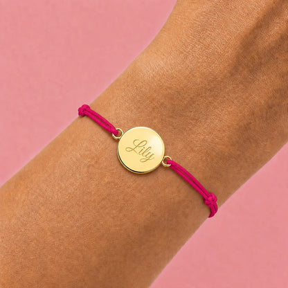 photo portée bracelet cordon mixte et ajustable personnalisé avec médaille dorée à graver et cordon rose framboise